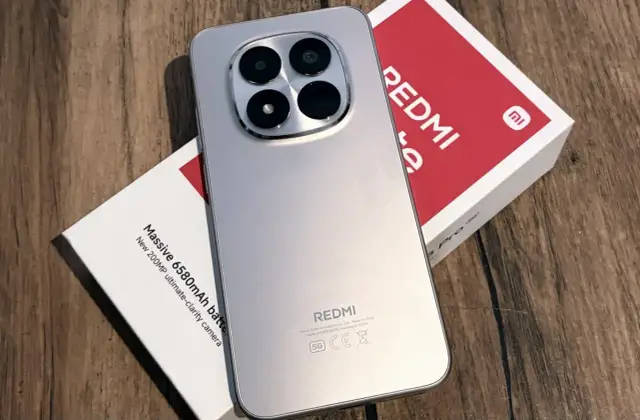 Srebrny, najnowszy Redmi z imponującym aparatem 200MP i baterią 6580mAh, leżący obok swojego czerwono-białego pudełka.