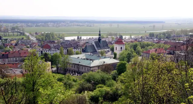 Widok na Pińczów z górującym kościołem i klasztorem. W oddali pola i lasy. Odkryj pińczów atrakcje!