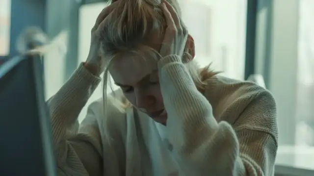 Kobieta z rękami na głowie, wyraźnie zestresowana. Czy to objawy podwyższonego kortyzolu? Co to jest kortyzol?