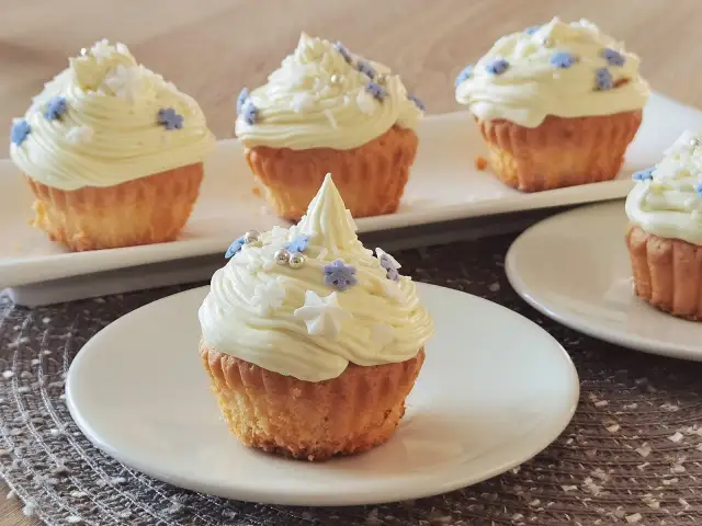 Babeczki z kremem i ozdobami w kształcie gwiazdek i kwiatków.