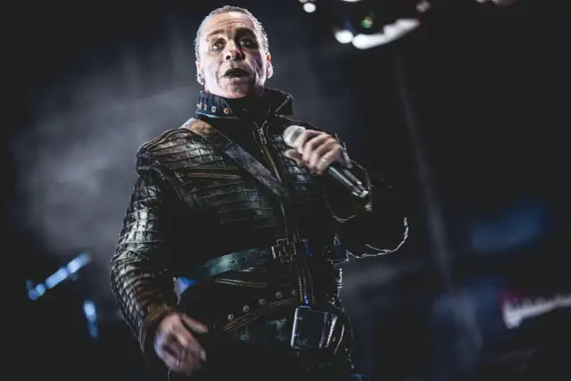 Till Lindemann w skórzanej kurtce, z mikrofonem w dłoni, jakby opowiadał historię swojej żonie.