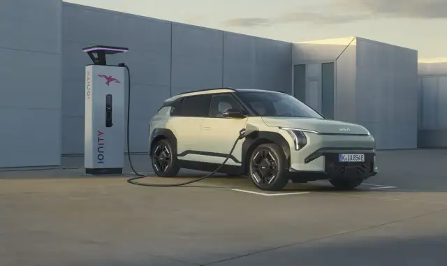 Jasnozielony samochód elektryczny Kia jest ładowany przy stacji Ionity. Obraz pokazuje, ile prądu pobiera samochód elektryczny podczas ładowania.