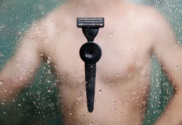 Czarna maszynka do golenia na mokrej szybie z serduszkami.