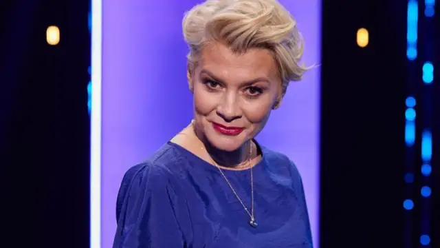 Uśmiechnięta prowadząca Magia nagości Polska sezon 3 w niebieskiej sukience.