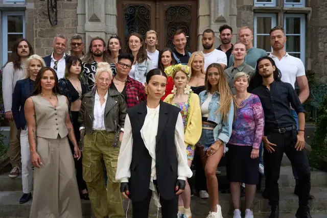 Grupa osób pozuje przed budynkiem. Czy wśród nich są "the traitors polska"?