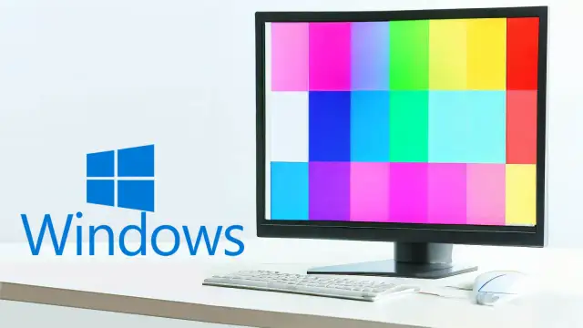 Monitor z kolorowymi pasami, logo Windows i klawiatura.