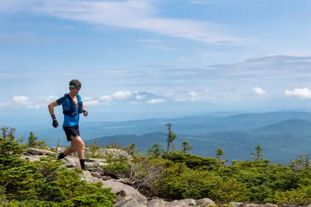 Biegacz na szlaku Appalachów, gdzie północ jak odnalazłem siebie. W tle błękitne pasma górskie i niebo.