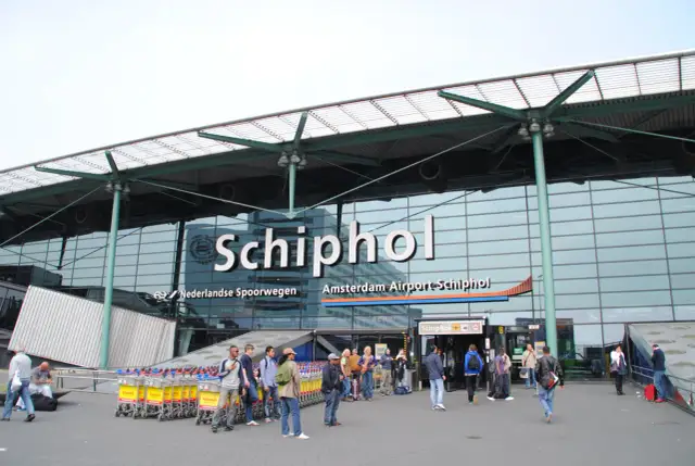 Na lotnisku Schiphol w Amsterdamie, obok wejścia, znajduje się znak z symbolem palenia, co sugeruje, że jest tam palarnia.