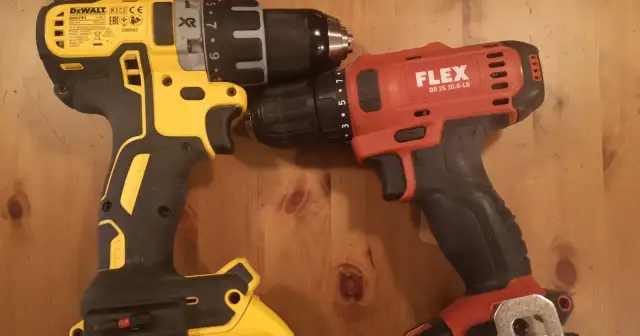 Dwie wkrętarki: żółto-czarna DeWalt i czerwono-czarna Flex, leżą obok siebie na drewnianym blacie.