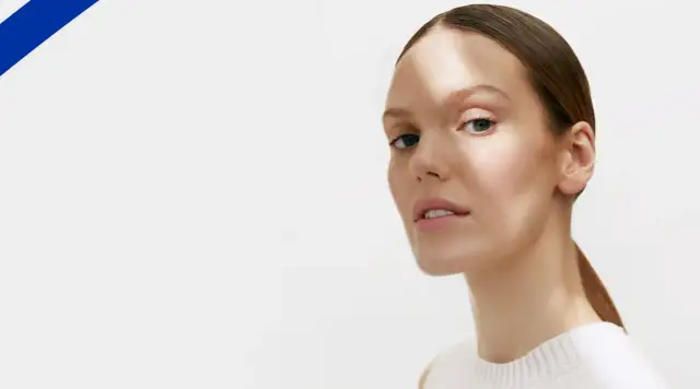 Kobieta z delikatnym makijażem, oświetlona słońcem, jakby po kuracji antybiotykiem, z czystą cerą.