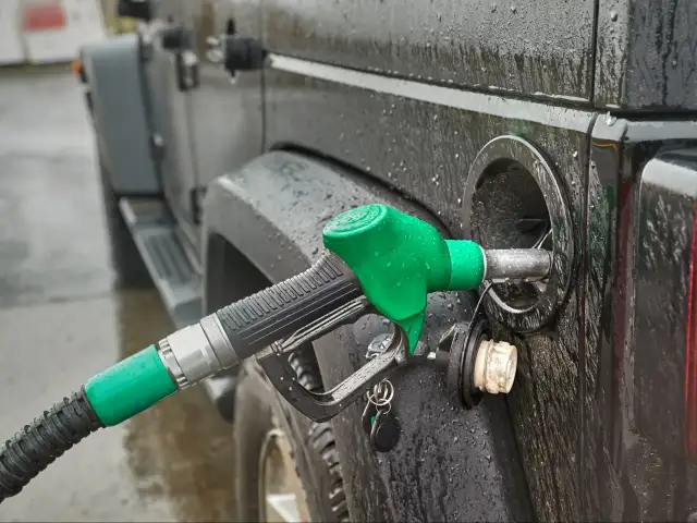 Tankowanie czarnego Jeepa w deszczu. Zastanawiasz się, ile paliwa można przewieźć przez granicę?