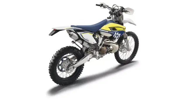 Husqvarna TE 250 gotowy do jazdy po bezdrożach. Biało-żółty motocykl terenowy z niebieskim siedzeniem.