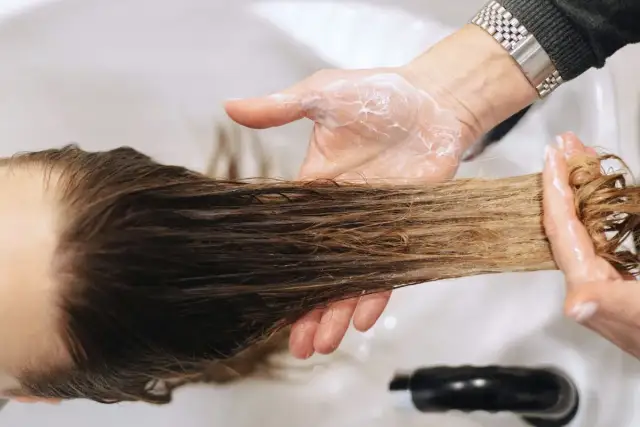 Dłonie w piance do włosów, aplikacja produktu na pasma. Czy botoks na włosy ma wady? Sprawdźmy.