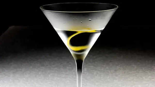 Ein Martini-Cocktail in einem Glas mit Zitronenzeste und Kondenswasser.