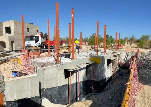 Construcción de un sótano en España, con pilares naranjas y hormigón.