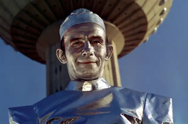 Henryk Bista w filmach, jako srebrny człowiek, pod futurystyczną konstrukcją.