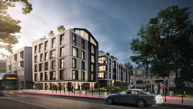 Nowoczesne apartamenty w Krakowie, z tramwajem i samochodem w ruchu. Ceny mieszkań w krakowie mogą być wysokie, ale warto zainwestować w taką lokalizację.