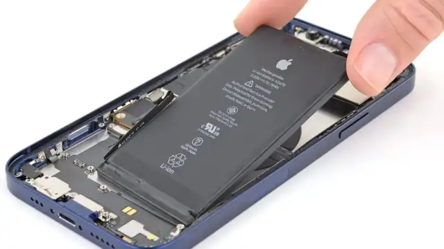 Wyjmowanie baterii z iPhone'a 13.