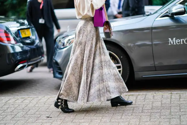 Eleganckie stylizacje ze spódnicą: zwiewna, wzorzysta spódnica maxi i botki z klamrami.