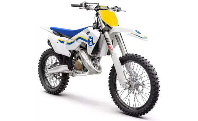 Biały motocykl crossowy Husqvarna 125 z niebieskim siedzeniem i żółtymi akcentami.