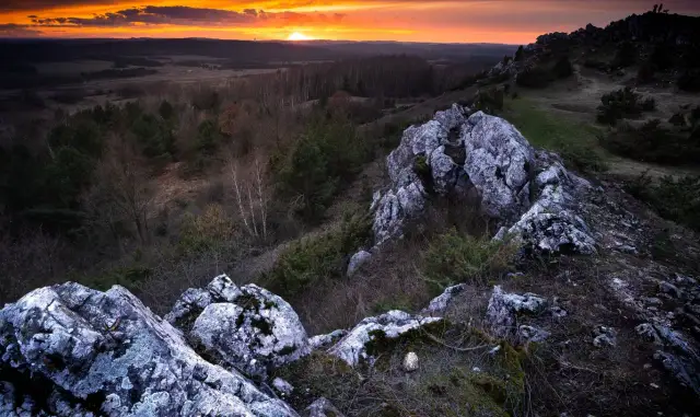 Zachód słońca nad Górami Świętokrzyskimi. Skaliste szczyty i lasy tworzą malowniczy krajobraz. Idealne miejsce, by zobaczyć piękno polskiej przyrody.