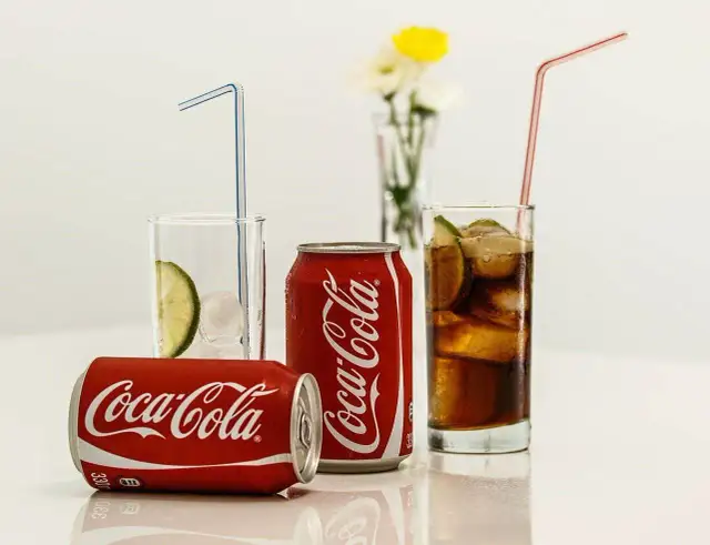 Puszki i szklanki z Coca-Colą, lodem i limonką. Zastanawiasz się, ile kalorii ma Coca-Cola?