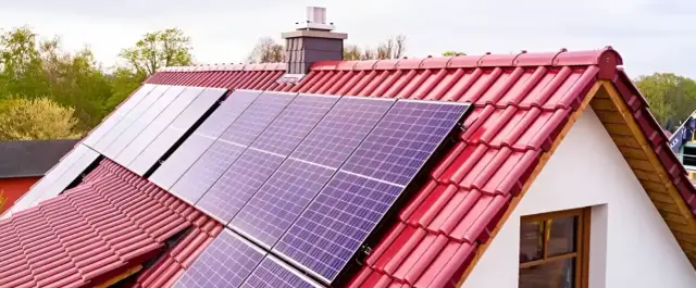 Panele fotowoltaiczne na czerwonym dachu, gotowe do mycia. Czysta energia dla domu.