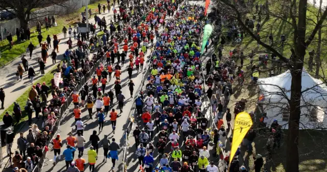 Tłum biegaczy na trasie maratonu, widziany z góry.
