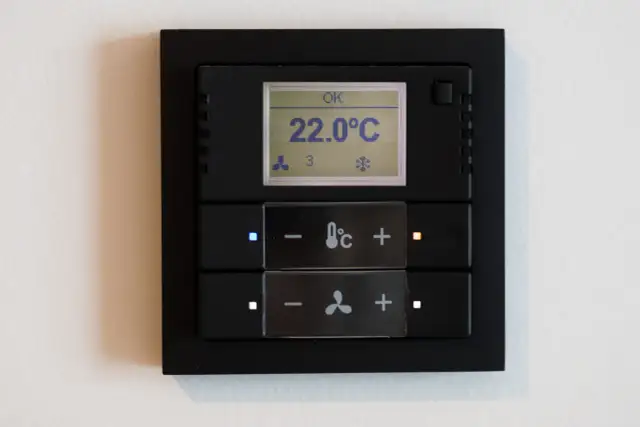 Panel klimatyzacji hotelowej z wyświetlaczem temperatury 22°C i przyciskami sterowania.