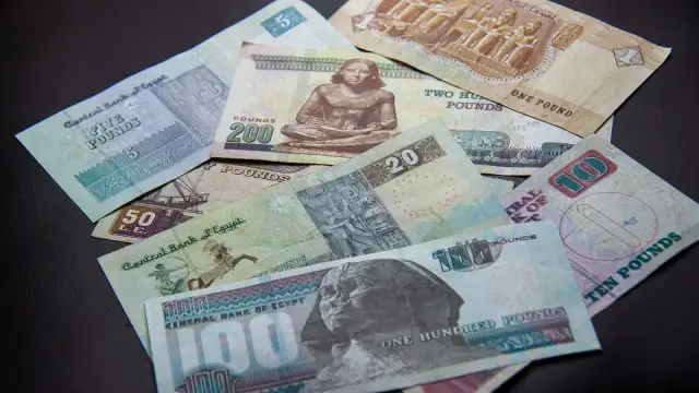 Egipskie funty, od 1 do 200, leżą na czarnym tle. Planujesz podróż i zastanawiasz się, jakie dolary do Egiptu? Lepiej zabrać funty!