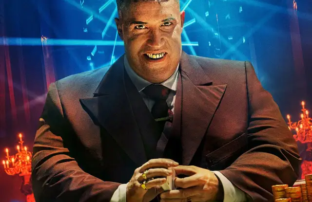 Złote zęby i złote pierścienie zdobią postać z obsady John Wick 4. W tle neonowe światła i stosy monet.