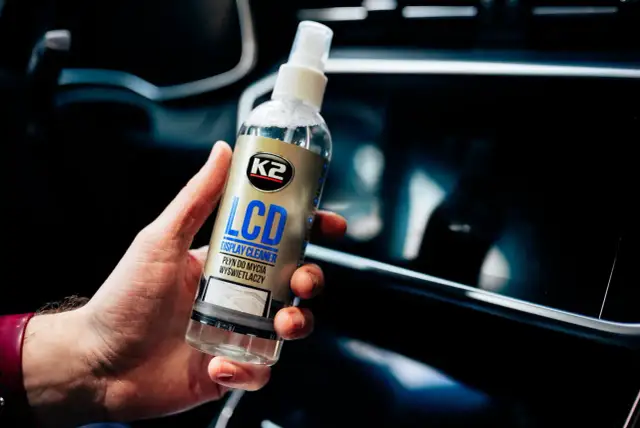 Dłoń trzyma płyn K2 LCD Display Cleaner, idealny do czyszczenia ekranu telefonu.
