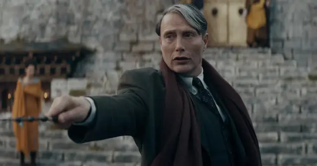 Mads Mikkelsen w roli Grindelwalda, z różdżką w dłoni, w filmie "Fantastyczne zwierzęta: Tajemnice Dumbledore'a".