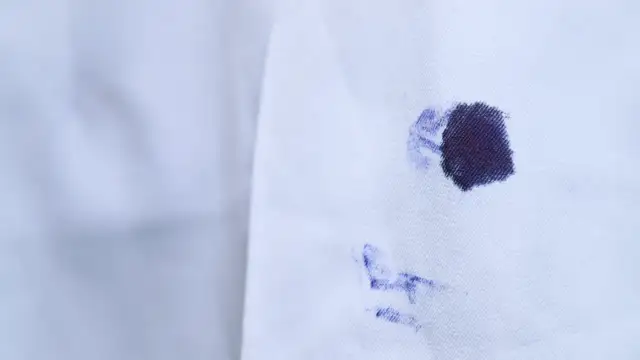 Plama z atramentu na białej tkaninie.