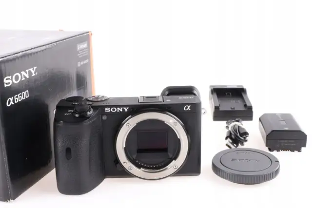 Aparat Sony Alpha 6600 z akcesoriami: pudełko, ładowarka, bateria, kabel i dekielek.