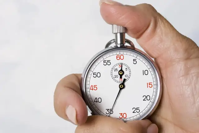 Dłoń trzymająca stoper z tarczą wskazującą czas.