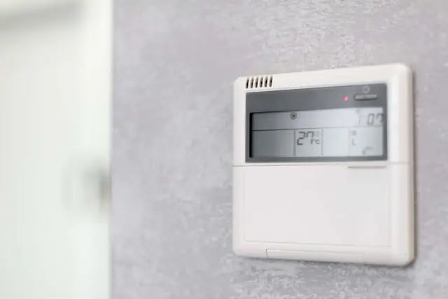 Panel klimatyzacji hotelowej pokazuje 27°C. Dowiedz się, jak ustawić klimatyzację w hotelu, by cieszyć się komfortem.