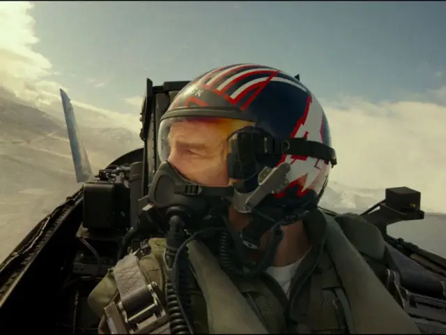 Pilot w kasku z flagą USA, gotowy do akcji w kokpicie myśliwca. Czy to zapowiedź Top Gun 3?