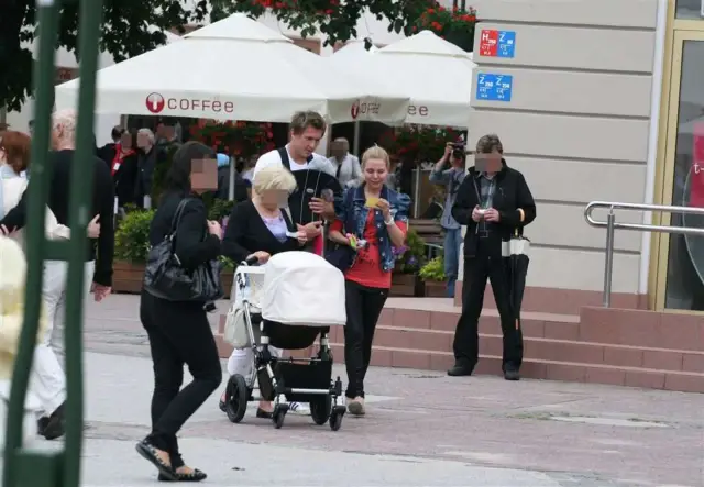 Tomasz Kuszczak z żoną i rodziną spacerują z wózkiem przy kawiarni "coffee".