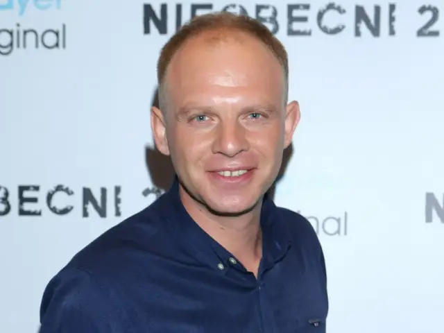 Kazimierz Mazur po przeszczepie włosów, uśmiecha się do kamery.