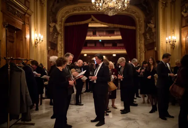 Eleganckie przyjęcie w teatrze. Ludzie rozmawiają, piją wino, zastanawiając się, co to jest antrakt.