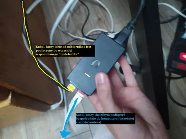 Ręka trzyma czarny adapter sieciowy. Żółty kabel od odbiornika jest podłączony do adaptera. Biały kabel sieciowy, który chcesz podłączyć do komputera, jest gotowy.