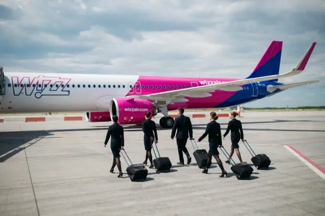 Załoga Wizz Air z walizkami idzie w stronę samolotu. Czyżby kolejny przypadek overbooking w Wizzair?
