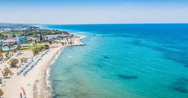 Wyspa Kos oferuje piękne plaże i turkusowe morze. Widok na wybrzeże z hotelami i leżakami zaprasza do wypoczynku.