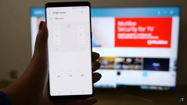 Smartfon z aplikacją do sterowania telewizorem, umożliwiający screen mirroring. Na ekranie telefonu widać przyciski pilota, a w tle telewizor z wyświetloną stroną internetową.