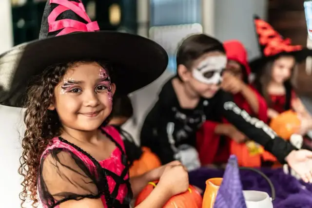 Dziewczynka w stroju czarownicy z makijażem na Halloween. Pomysł na to, jak zrobić strój czarownicy dla dziewczynki.