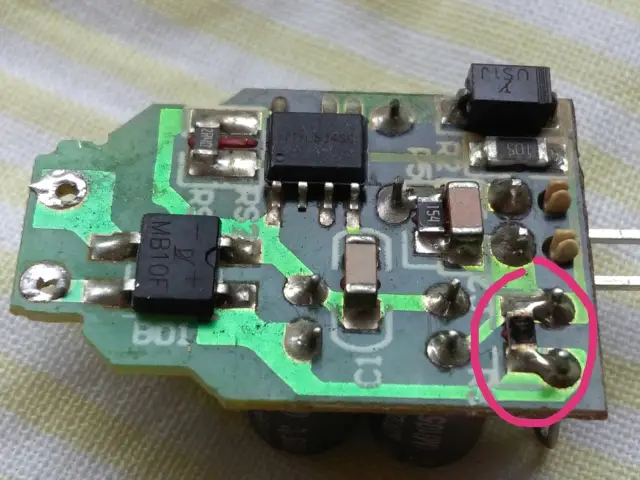 Płytka drukowana z elementami elektronicznymi, gdzie lampa led miga jak stroboskop. Widoczne kondensatory, rezystory i diody.