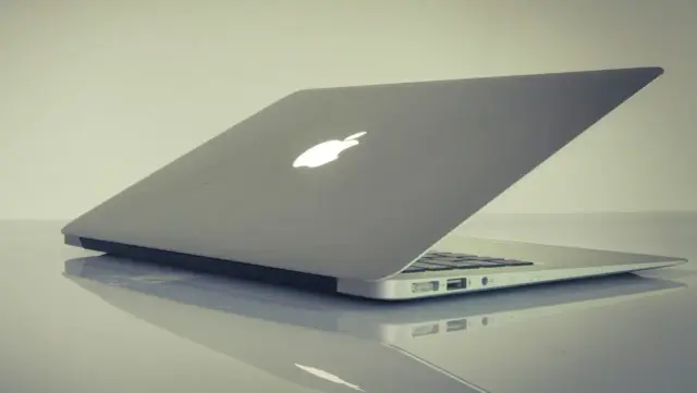 Srebrny laptop Apple z podświetlanym logo. Dowiedz się, jak zrobić zrzut ekranu na laptopie.