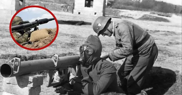 Żołnierz w masce gazowej przygotowuje panzerfaust, podczas gdy drugi żołnierz pochyla się nad nim. W okręgu widać nowoczesny żołnierz celujący z podobnej broni.