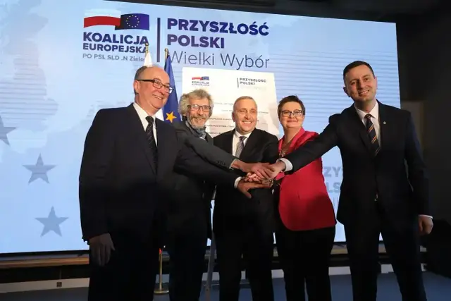 Pięcioro polityków zjednoczonych w koalicji, dłonie złożone na znak porozumienia.